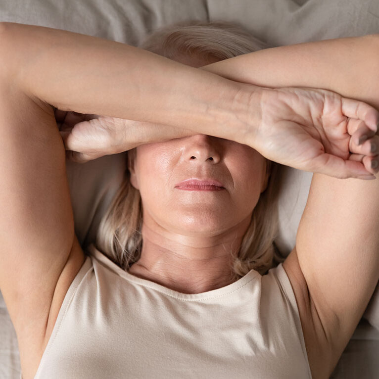 woman laying in bed who can't sleep